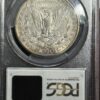 A silver dollar coin is sitting on top of a black case.