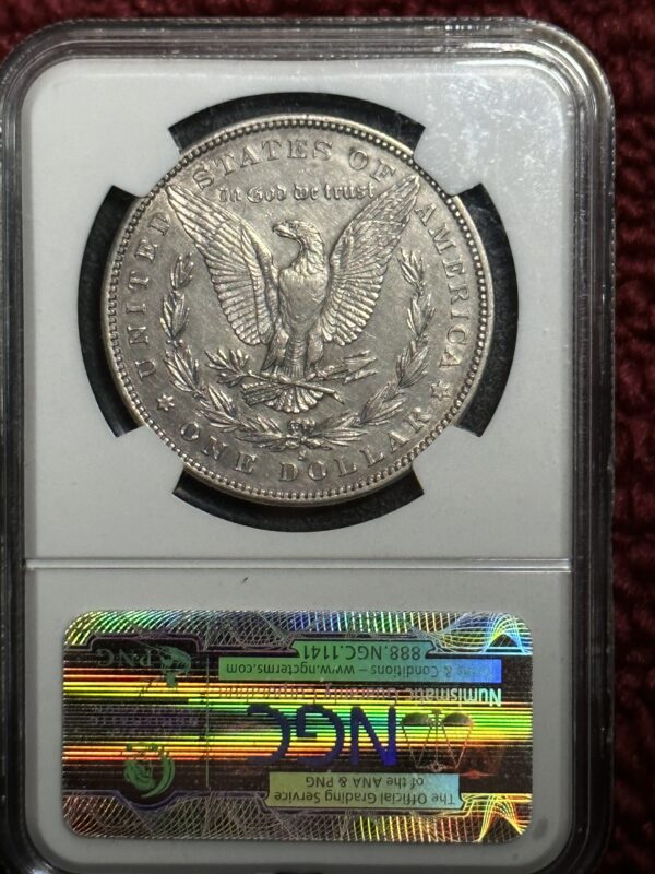 A silver dollar is on display in an old frame.