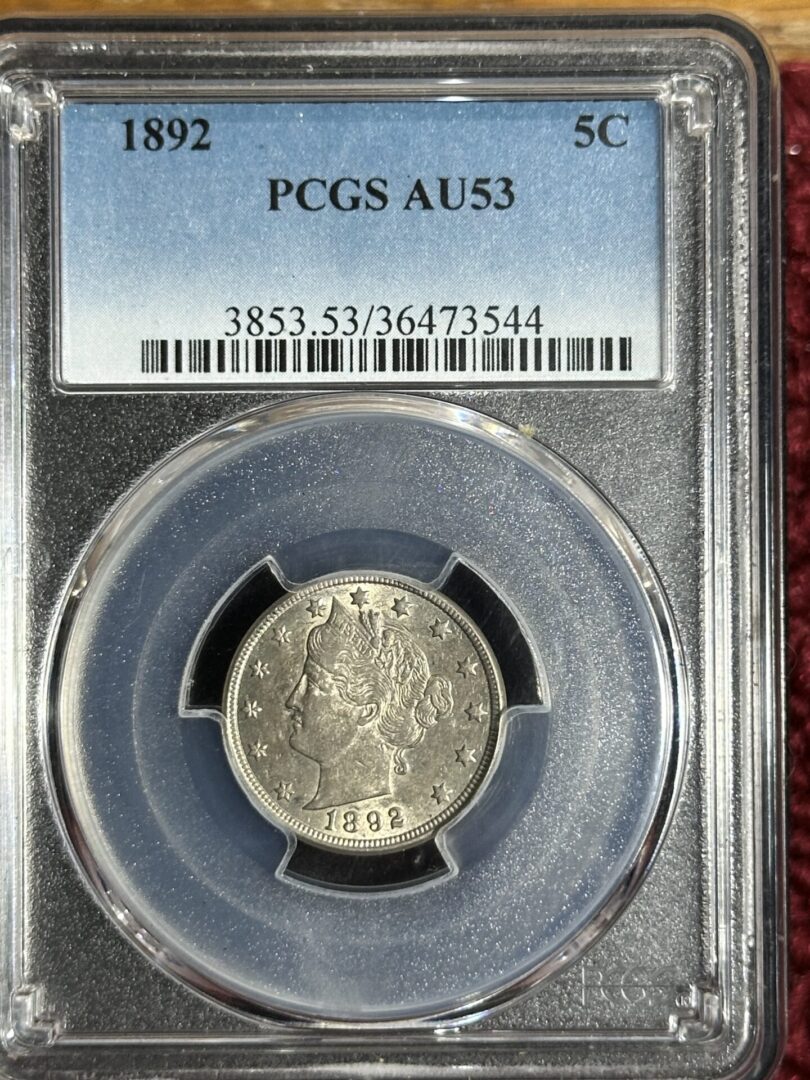 A 1892 Liberty Nickel PCGS AU53 coin encased in a clear protective holder with a label displaying grading details.