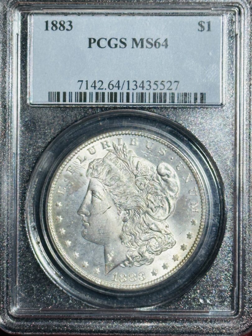 1883 Morgan Dollar PCGS MS64 in a grade case, showing the head of lady liberty and the year on the obverse side.