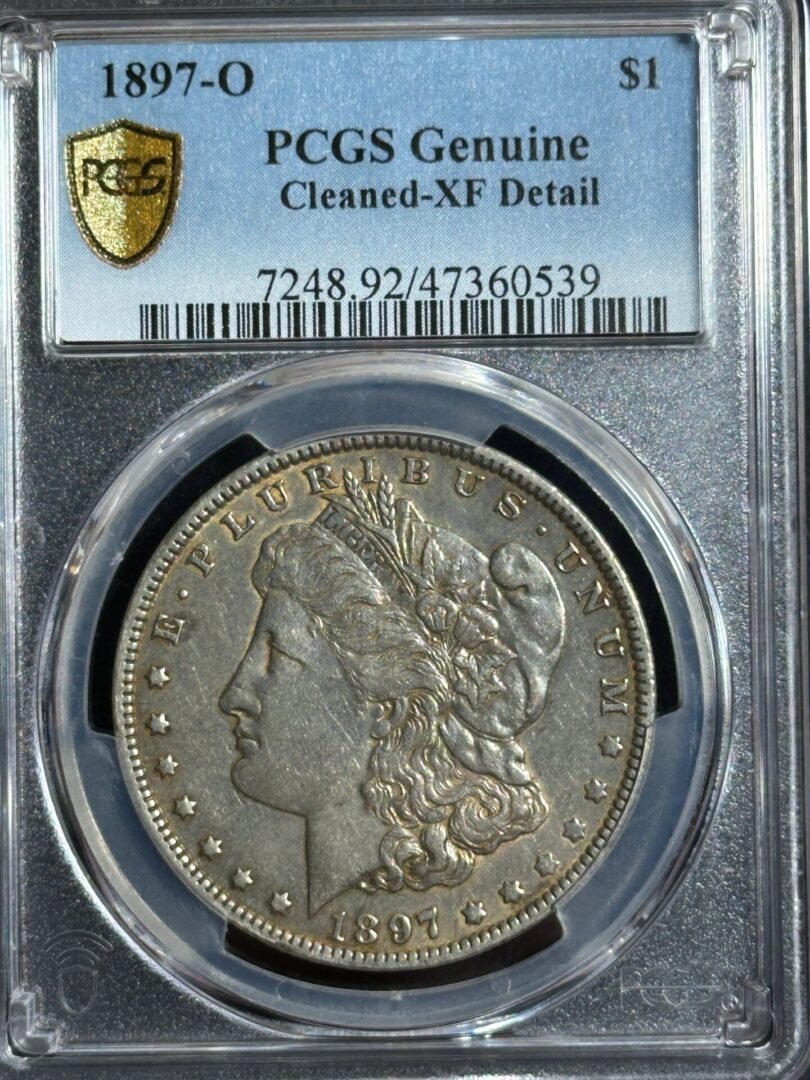 1897-o morgan silver dollar in pcgs holder labeled as genuine with cleaned xf detail, showing the obverse side with liberty's profile and stars.