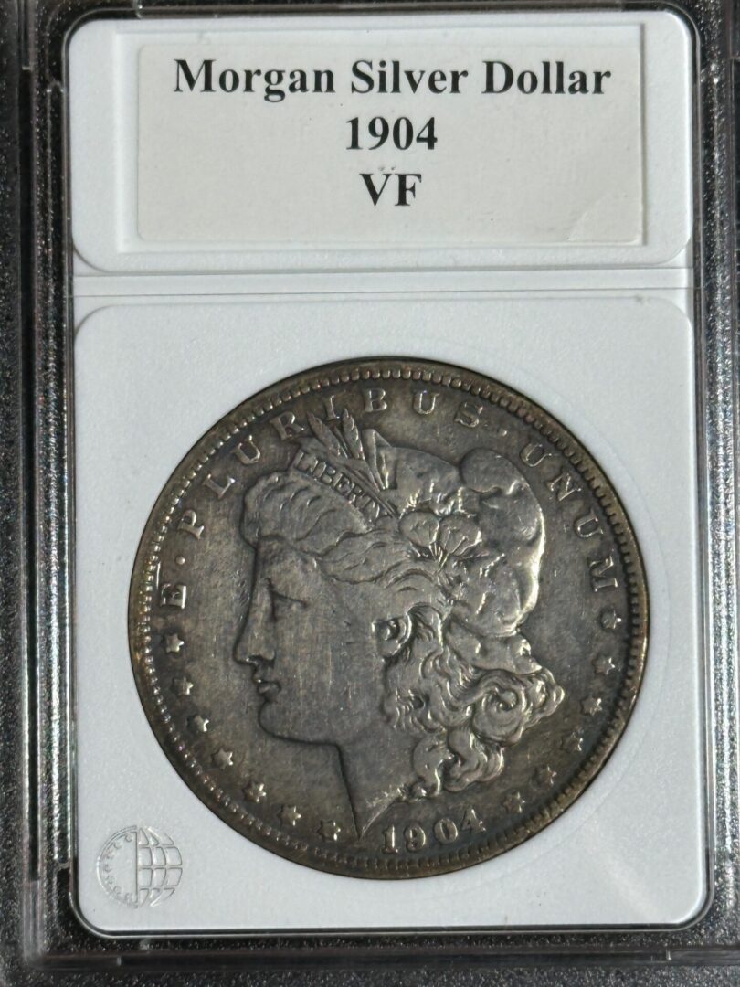 A 1904 morgan silver dollar graded vf, encased and labeled for preservation and display.