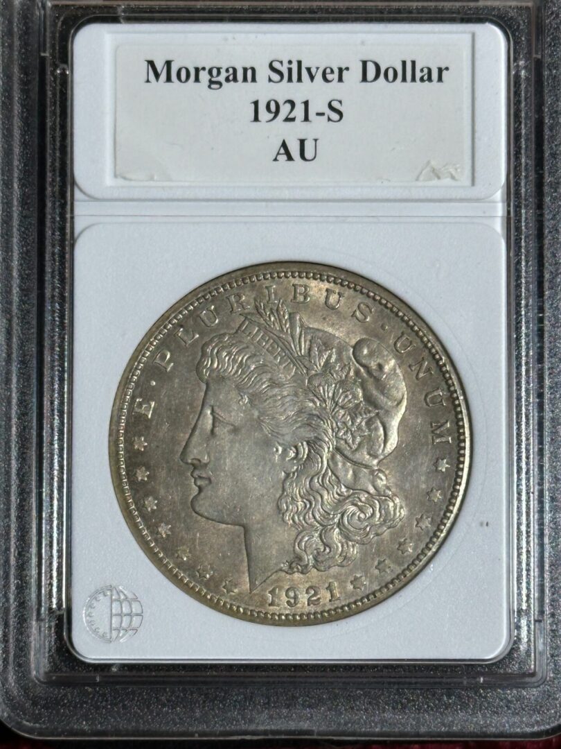 A 1921-s morgan silver dollar encased in a collector's slab, graded au, showing detailed obverse features.