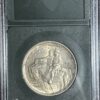 A 1925 Stone Mountain Commemorative AU58 featuring the yorktown surrender, encased in a protective clear holder with a black frame.