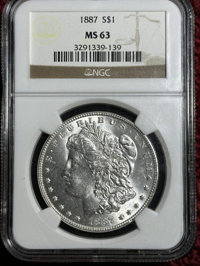 1887 Morgan Dollar NGC MS63 with detailed profile of lady liberty, labeled "ms 63" by ngc and enclosed in a protective case with identification numbers.